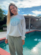 Amy wearing an Inhale Exhale white crewneck by the pool